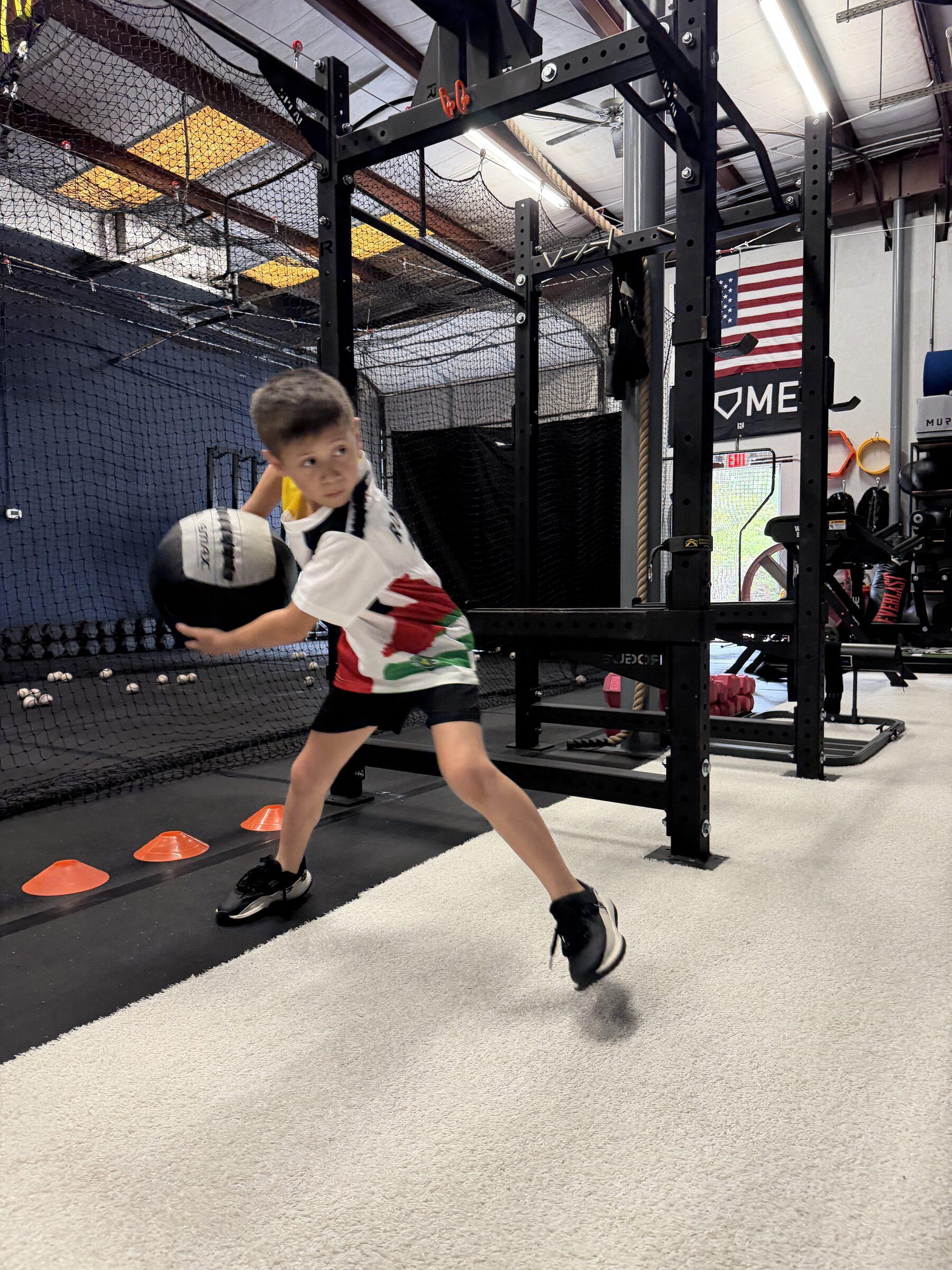 Young athlete training with a medicine ball at TideHaus Fitness